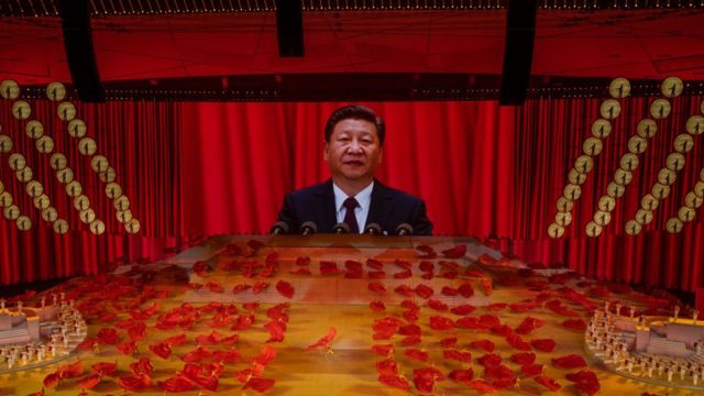 Chinese President and Chairman of the Communist Party Xi Jinping appears on a large screen as performers dance during a mass gala marking the 100th anniversary of the Communist Party on 28 June 2021.