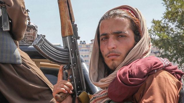 Taliban fighters are seen on the back of a vehicle in Kabul