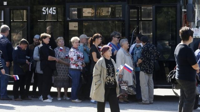 Locals wait in line to board special buses to travel to polling stations in the Russian Rostov Region to take part in the parliamentary election at the pro-Russian militants-controlled city of Donetsk, Ukraine, 18 September 2021