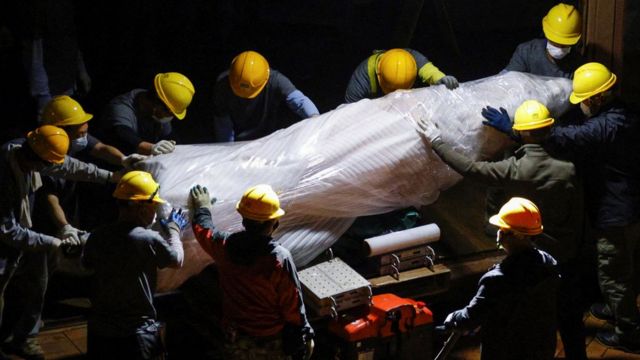 Construction workers remove the statue