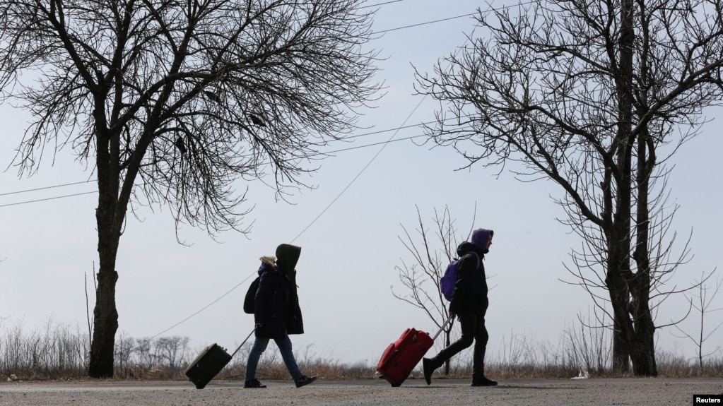 Hai người đang rời khỏi Mariupol của Ukraine, đi lánh nạn.